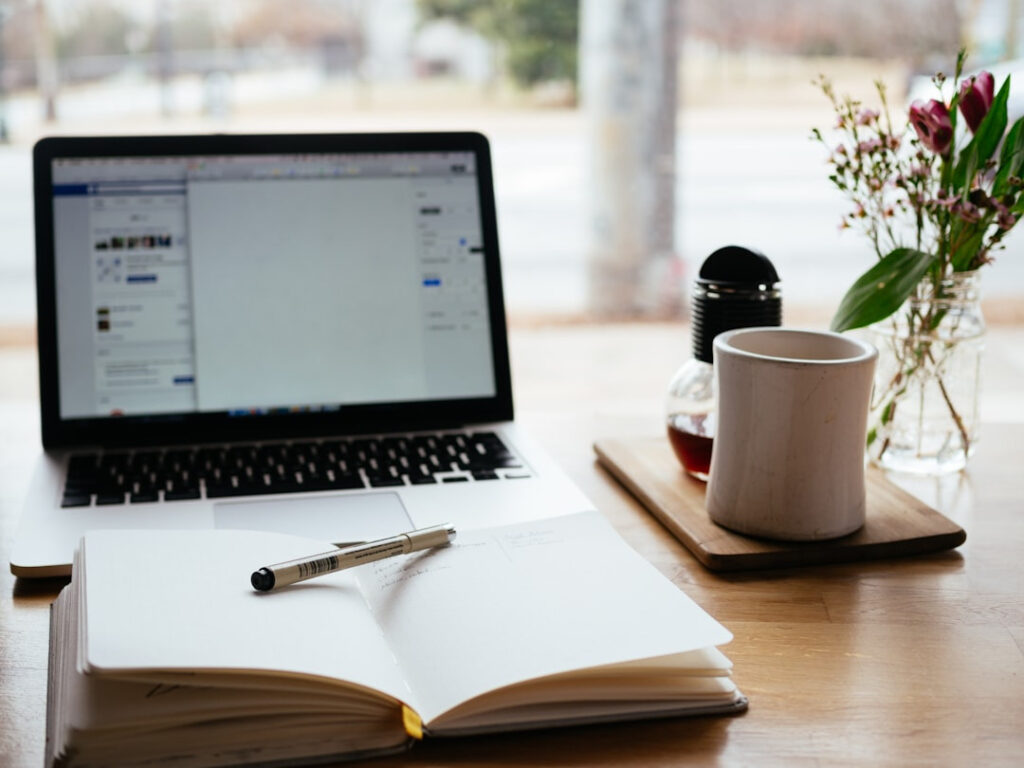 Desk workspace with laptop and notebook for WordPress Web Design Services